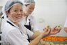 2018年9月17日，在浙江省杭州市临安区天目山镇一家食品厂内，员工在展示手工制作的中秋月饼。