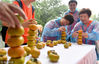 2018年9月22日，杭州西溪湿地，游客们在火柿映波的美丽秋色中，感受丰收的喜悦。 游客们在西溪湿地丰收市集玩叠柿子的游戏。