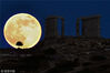 当地时间2013年6月23日，希腊雅典南部65公里的波塞冬海神庙旁看到的满月景观。ARIS MESSINIS/视觉中国