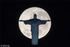 当地时间2016年7月19日，巴西里约热内卢，满月映照出基督雕塑的轮廓。YASUYOSHI CHIBA/视觉中国
