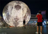 2018年9月23日，市民在南京街头布置的超级“月亮”景观球前留影。