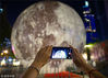 2018年9月23日，市民在南京街头布置的超级“月亮”景观球前拍照。