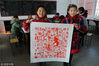 2019年1月10日，江苏连云港，非物质文化遗产代表性传承人李伟与小学生一起制作“百猪图”。