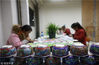 2019年1月10日，在贵州省丹寨县一家民族银饰加工坊内，技术工人在给银碗上釉彩。