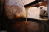 2018年12月25日，浙江慈溪。胡逸毅在搅拌麦芽糖，他的麦芽糖是炒制出来的，属于独门绝技。