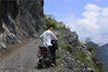 2018年8月2日，湖北宜昌。李传锦骑着摩托车，通过一段悬崖，这是他走访贫困户的必经之道。