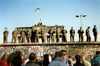 当地时间1989年11月11日，德国柏林，图为东德边境守卫站在一段柏林墙上，身后是著名的勃兰登堡门。GUNTHER KERN/视觉中国