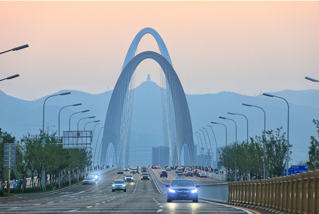 北京：夕阳西下 市民在新首钢大桥上拍美景
