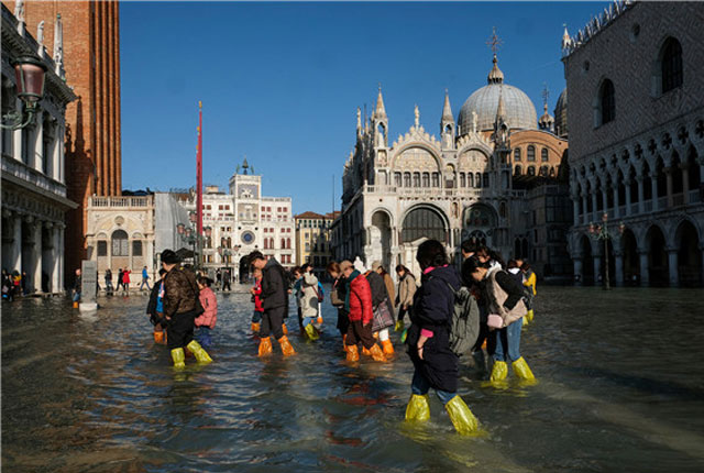 威尼斯遭50年一遇洪灾侵袭  游客穿雨鞋套走临时浮桥继续游览
