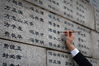 2019年11月18日，南京审计大学的志愿者为侵华日军南京大屠杀遇难者名单墙（又称“哭墙”）上的遇难者名字逐一“描新”，寄托哀思。  泱波(江苏分社)/中新社/视觉中国
