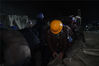 2019年11月27日23时21分，云南临沧，云（县）凤（庆县）高速公路第二合同段安石隧道突泥涌水事故现场，工人正在加紧装填沙袋。