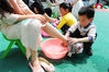 2016年5月5日，安徽省阜阳市颍州区小红帽幼儿园大班的小朋友在感恩母亲活动中在给妈妈们洗脚。王彪/视觉中国