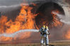 当地时间2013年10月23日，韩国仁川，仁川国际机场举行2013年飞机事故处理消防演习，消防员正在扑灭模拟坠机后飞机引擎发生的火灾。Yonhap/视觉中国