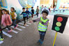 2014年11月3日，浙江德清县第一实验幼儿园小交警在模拟红绿灯前，用准确的手势指挥同学们安全过斑马线。小绍兴/视觉中国