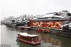 2019年2月8日，游客乘坐画舫在南京夫子庙附近的秦淮河上游览，秦淮河两岸雪景如画。