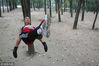 2010年9月15日，辽宁省鞍山市一二九公园内，一名男青年“躺在”一根绳子上休息。这名男青年在绳子上躺卧的最高记录是7小时。older/视觉中国