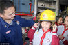 2019年3月25日，江苏省苏州市平江新城实验小学的学生在消防员的指导下体验戴消防帽。