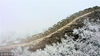 2019年4月9日，白雪覆盖下的箭扣长城银装素裹，春雪飘落与蜿蜒长城同在，云雾缭绕与桃花盛开辉映。构成一幅幅美丽画卷（无人机拍摄））。
