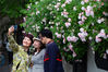 2019年4月22日，市民在南京市西康路盛开的蔷薇花下自拍留念。暮春时节，南京街头多处蔷薇花盛开，清香四溢，吸引人们前来赏花拍照。