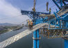 2019年5月10日，湖北襄阳，在庞公大桥施工现场，工人接收塔吊运送的施工材料。