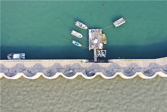 青岛：码头堤坝似花边镶嵌海面 蓝绿乳灰海水相映成趣