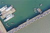 2019年5月23日下午，山东青岛西海岸新区唐岛湾，码头挡浪堤坝外的海面呈现出乳灰色颜色，堤坝内的海面则呈现蓝绿色颜色，两种色彩交相辉映。
