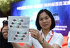2019年6月15日，浙江金华，市民在首发现场展示中欧班列（义乌—马德里）特种邮票。