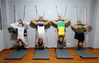 2014年8月6日，福建泉州，一家瑜伽健身馆内，几名年轻人正在墙壁上练习瑜伽“艾扬格”头倒顶动作。