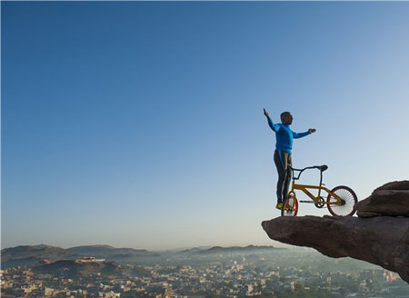 印度花甲老人悬崖边练习自行车瑜伽