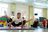 2017年5月22日，杭州仙林实验幼儿园，30余名青年幼师和全职妈妈在杭州著名“瑜伽爷爷”乐明潮老人的带领下学习瑜伽入门动作。