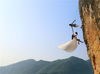 2014年10月26日，浙江金华一攀岩爱好者携老婆爬到20多米高的悬崖上拍婚纱照。方晟/视觉中国