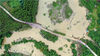 2019年7月15日，广西柳州，鱼峰区白沙镇一条乡道被柳江倒灌洪水淹没，村民骑车冒险涉水通行。
