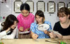 2019年7月19日，美国留学生在江苏苏州卢福英刺绣培训学校学习刺绣技艺。