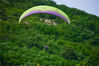 不同于飞机和热气球，滑翔伞的唯一动力就是风，专业的说法是利用太阳照射在陆地上产生的上升气流作为动力。滑翔伞运动员需要通过气象学知识和自己的经验找到上升气流从而完成飞行。图为2019年06月29日，山东青岛，300多个小时的飞行时间，赵伟算得上青岛滑翔伞玩家里的高手。但技术再高，也难免会遇上意外。