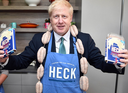 英国首相候选人鲍里斯身上挂满香肠 体验制作工艺化身“推销员”喜感十足