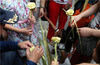 2014年8月2日，浙江省杭州市，编制绿玫瑰的师傅被大家围了个严严实实。这种绿色玫瑰是用棕榈叶编制而成，颇受大家的喜爱。