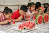 2019年8月8日，江苏省常州市西林街道东岱社区的小朋友在吃西瓜“啃秋”。陈暐/视觉中国