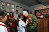 2019年9月9日，成都，成都市泡桐树小学的学生在参观“时光博物馆”为90岁的老军人赵保福戴红领巾。