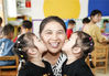 2019年9月9日，江苏淮安，幼儿园一对双胞胎小朋友亲吻老师。赵启瑞/视觉中国