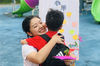 2019年9月10日，山东烟台，幼儿园的小朋友在教师节感恩展板前与老师拥抱。孙文潭/视觉中国 编辑/康娜
