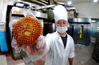 2019年9月7日，在安徽省安庆市大观区，一家老字号清真食品企业的员工展示生产的平价中秋月饼。江胜/视觉中国