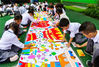 2019年9月26日，江苏扬州汶河幼儿园的小朋友们在摆出“70”字样的百米长卷上绘心中蓝图为祖国母亲庆生。