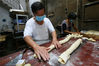 2019年9月5日，在安徽省黄山市休宁县万安老街一家糕点作坊，制饼艺人程贵生正在手工擀制面皮。