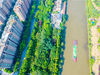 2019年9月8日，江苏南通，一条条运输船只从河水碧波的如皋如泰运河经过，与一幢幢高楼，一条条河道，两岸绿色植被构成一幅秋景美图画。