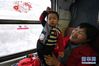 1月10日，在由兰州开往武威南的7505次列车上，从兰州探亲归来的把兰儒（右）和一岁半的小孙子乘车，准备返回永登县。 新华社记者 马宁 摄