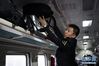 1月10日，在由兰州开往武威南的7505次列车上，列车长陈曦在整理行李。 新华社记者 马宁 摄