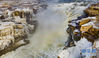 1月12日拍摄的黄河壶口瀑布主瀑（无人机照片）。 隆冬时节，位于晋陕交界的黄河壶口瀑布飞溅的浪花在瀑布两岸岩石上凝结形成冰瀑冰雕，成为冬季壶口瀑布景区一道奇特的景观，吸引游人前往观赏。 新华社记者 陶明 摄