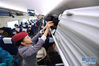 　1月14日，南昌铁路局福州客运段列车长樊思萱在动车上整理行李。