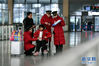 　1月15日，刘凤敏（右二）带着徒弟一起为重点旅客提供服务。新华社发（周牧 摄）