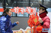 　1月15日，在蚌埠站候车大厅内，刘凤敏的徒弟严海婷（右）向旅客赠送新年礼品。新华社记者 韩晓雨 摄